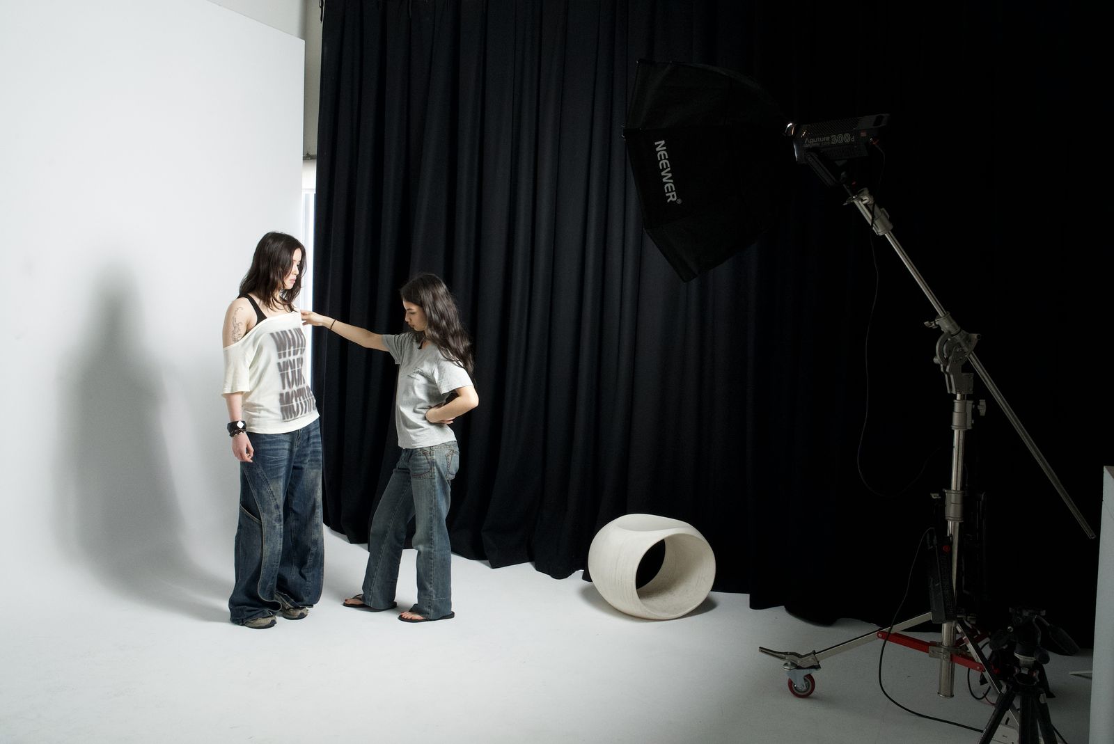 Fitting a printed tee on a model in front of a black curtain with studio lighting