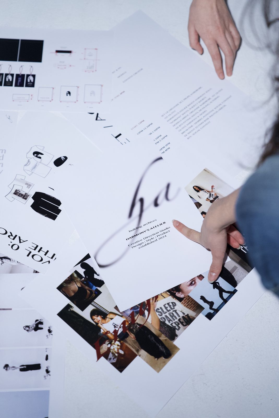 Hands sorting through Harmony's Atelier brand prints and collage sheets